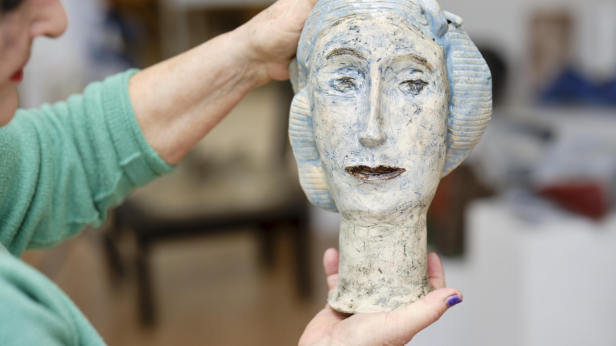 Christina Renker hält eine Statue eines Kopfes in der Hand