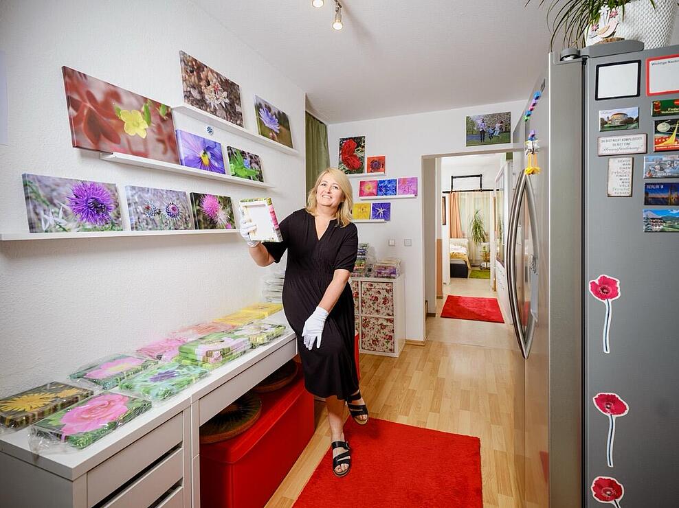 Svetlana in ihrer Wohnung mit Ausstellung ihrer Wildblumen-Fotografie