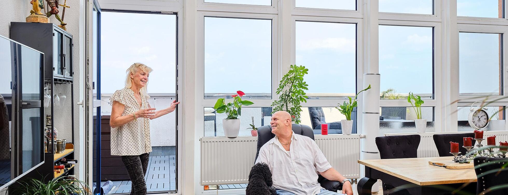 Monika und Andreas Graf zusammen mit ihrem Hund in ihrer Wohnung