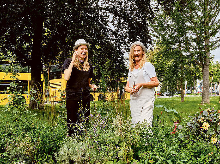 Außenaufnahme: Vier Personen bei der Gartenarbeit in einem Blumenbeet, im Hintergrund ein gelber Bus