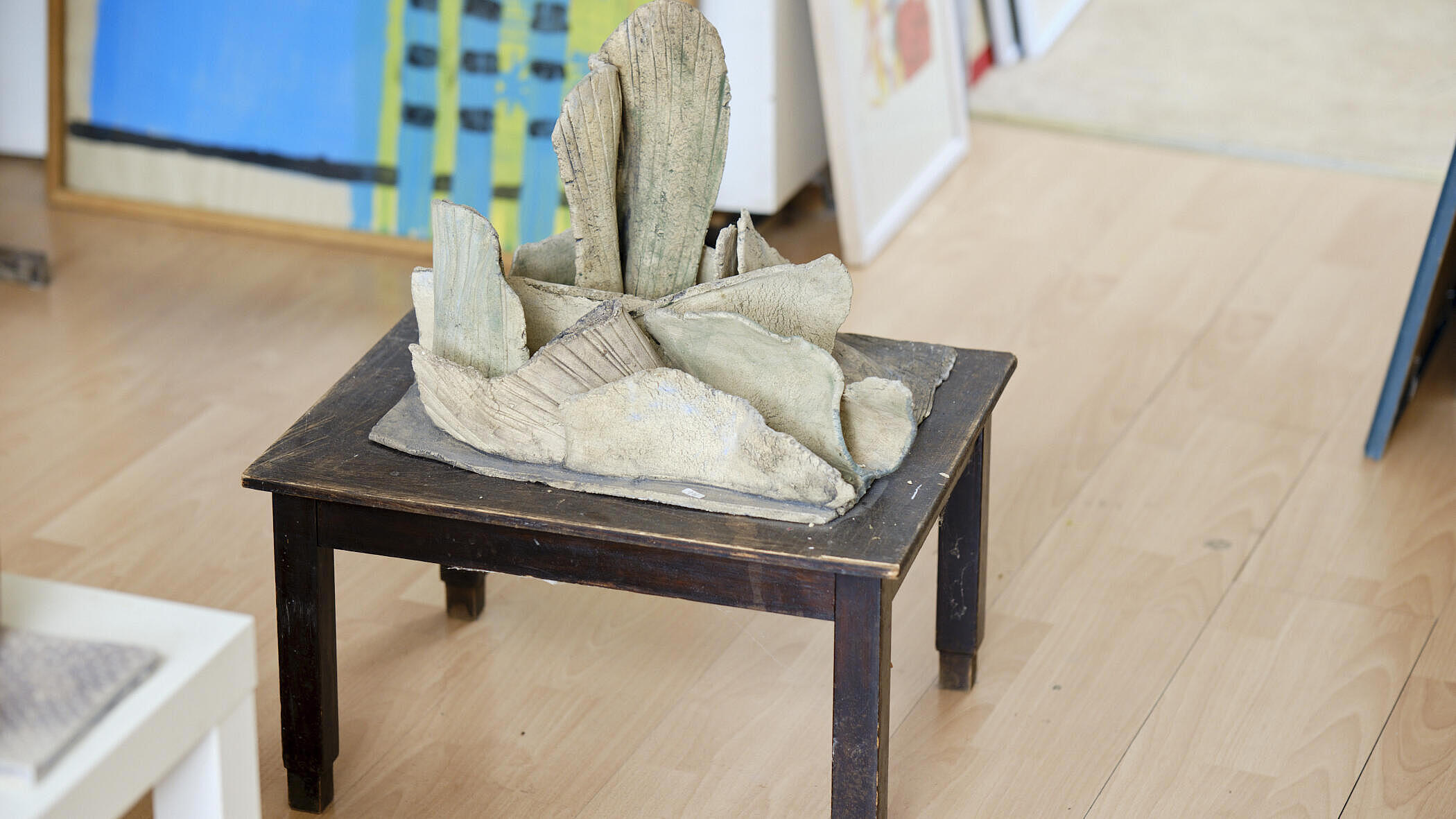 Eine graue Statue auf einem Holzbeistelltisch