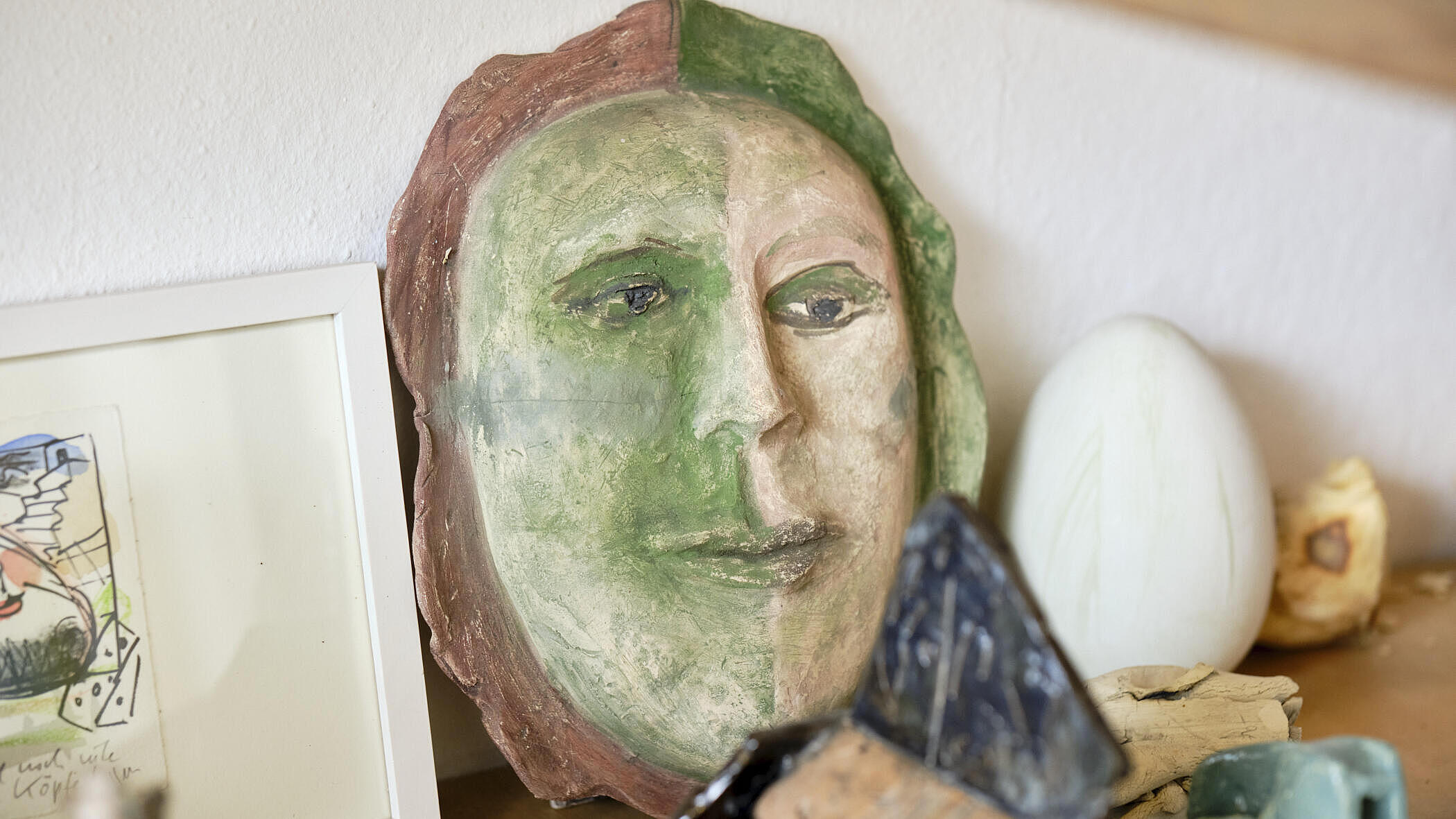 Ein grünes Gesicht aus Keramik in der Werkstatt