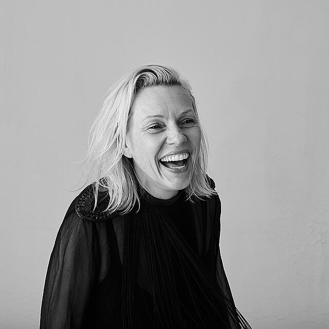 Fotografin Sonja Mueller lacht in einem Schwarz-Weiß-Portrait