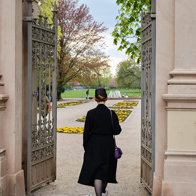 Christin Nichols geht durch das Tor in den Bürgerpark Pankow