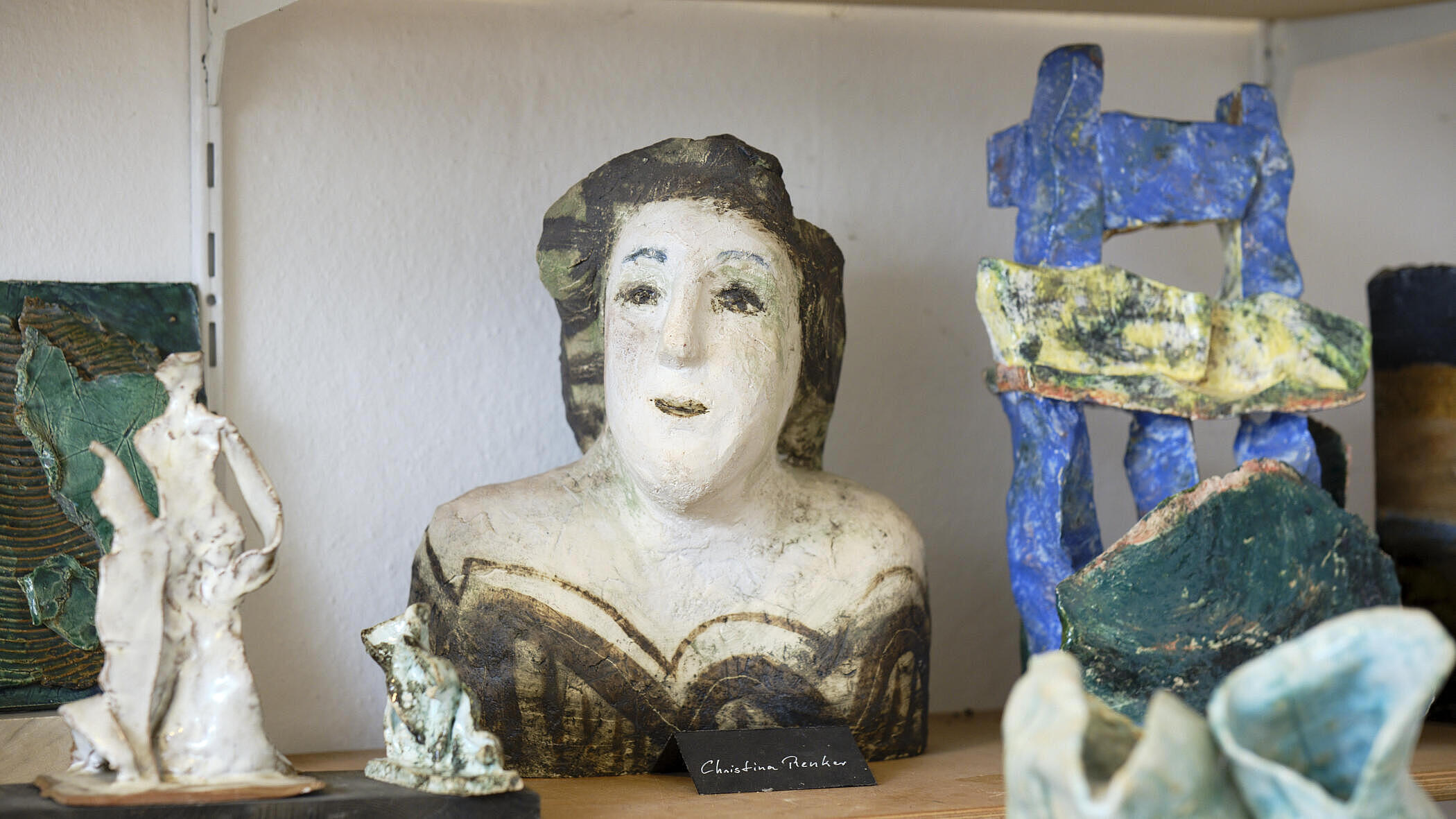 mehrere Ausstellungsstücke aus Keramik mit Sillouetten von Personen