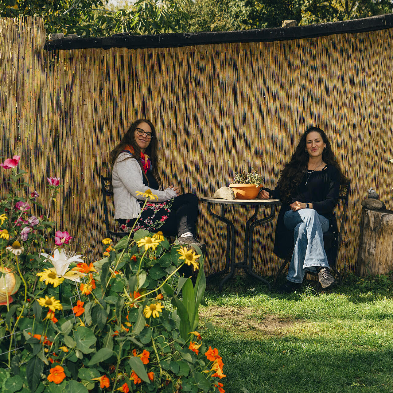 Im Garten des Wagendorfs sitzen Martina und Irina