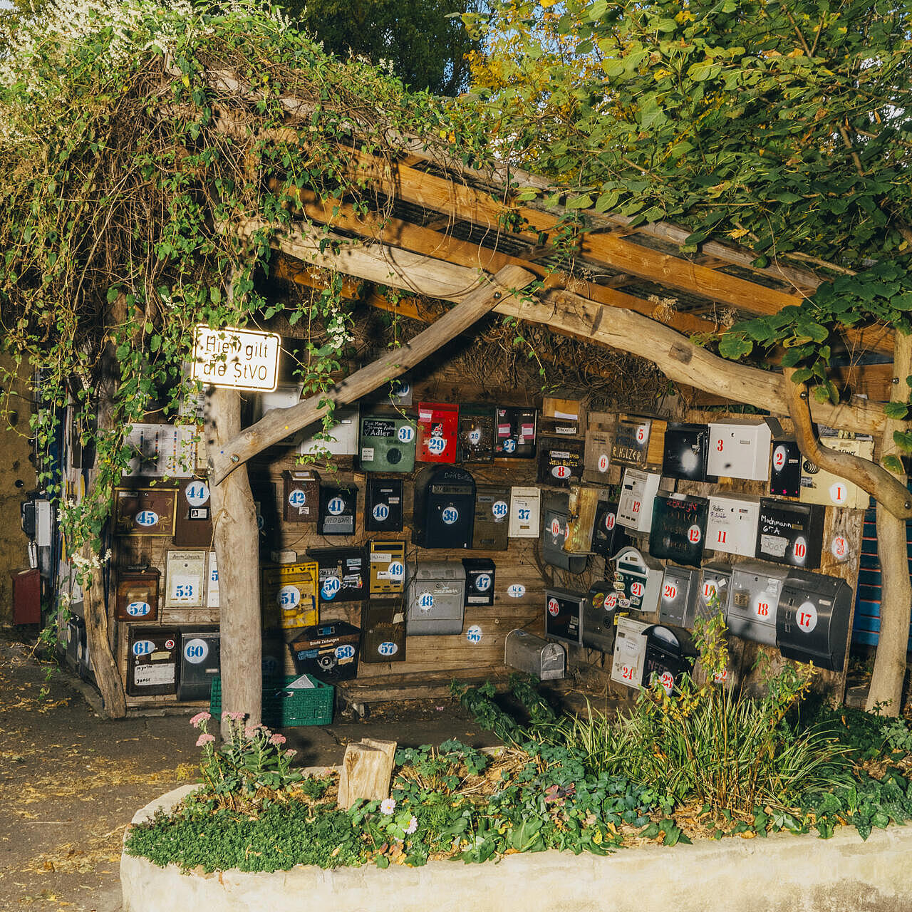 Briefkästensammlung des Wagendorf mit natürlich-inspirierter Überdachung aus Holz und Grün