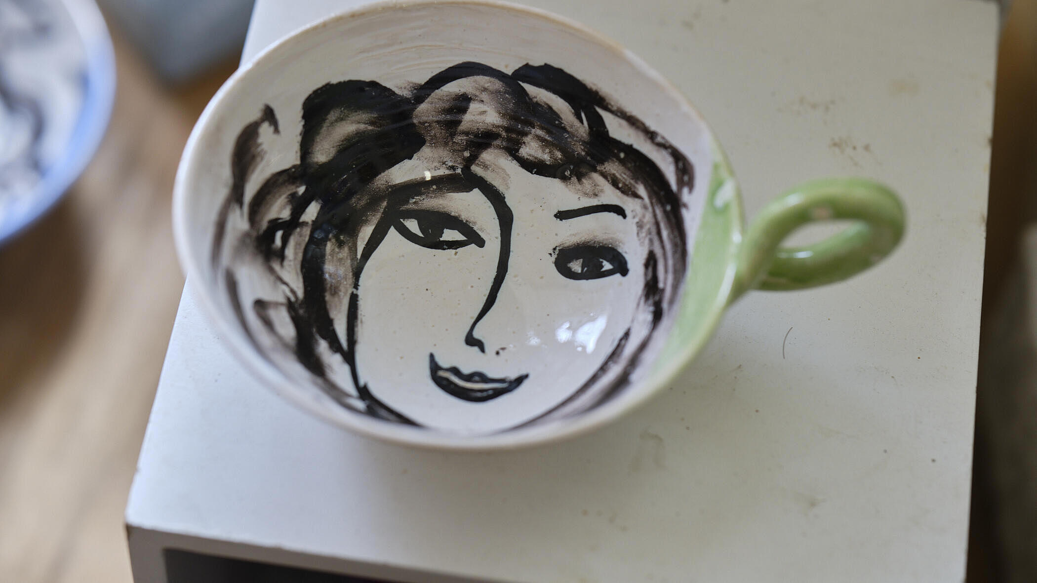 im Inneren einer Tasse zeigt sich ein Gesicht